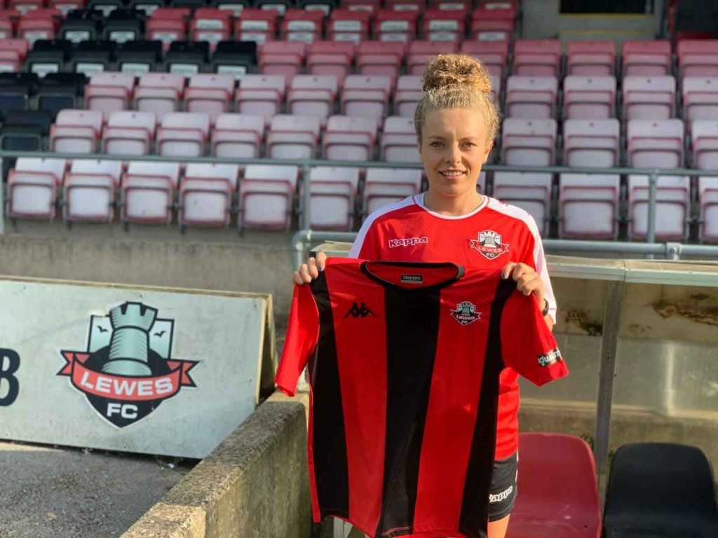 Emily Donovan holding up Lewses FC Women shirt