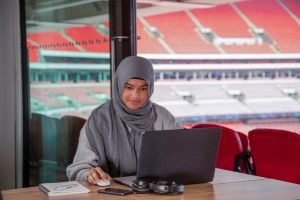 UCFB student working on laptop at Wembley Stadium