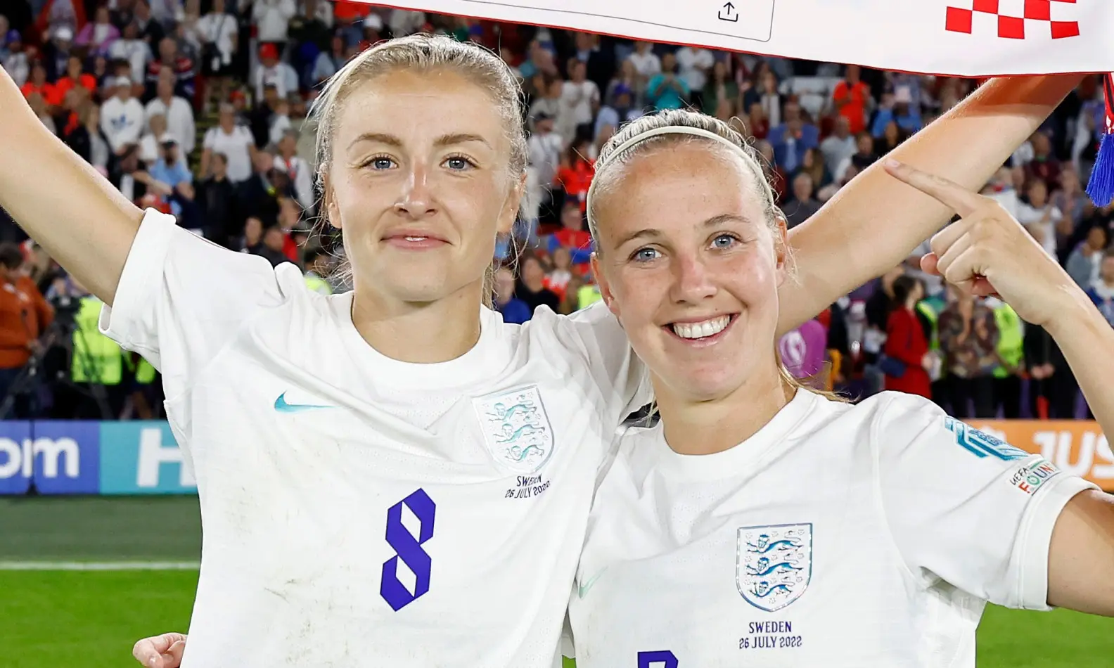 Leah Williamson and Beth Mead celebrating together after a match in England's football kit.