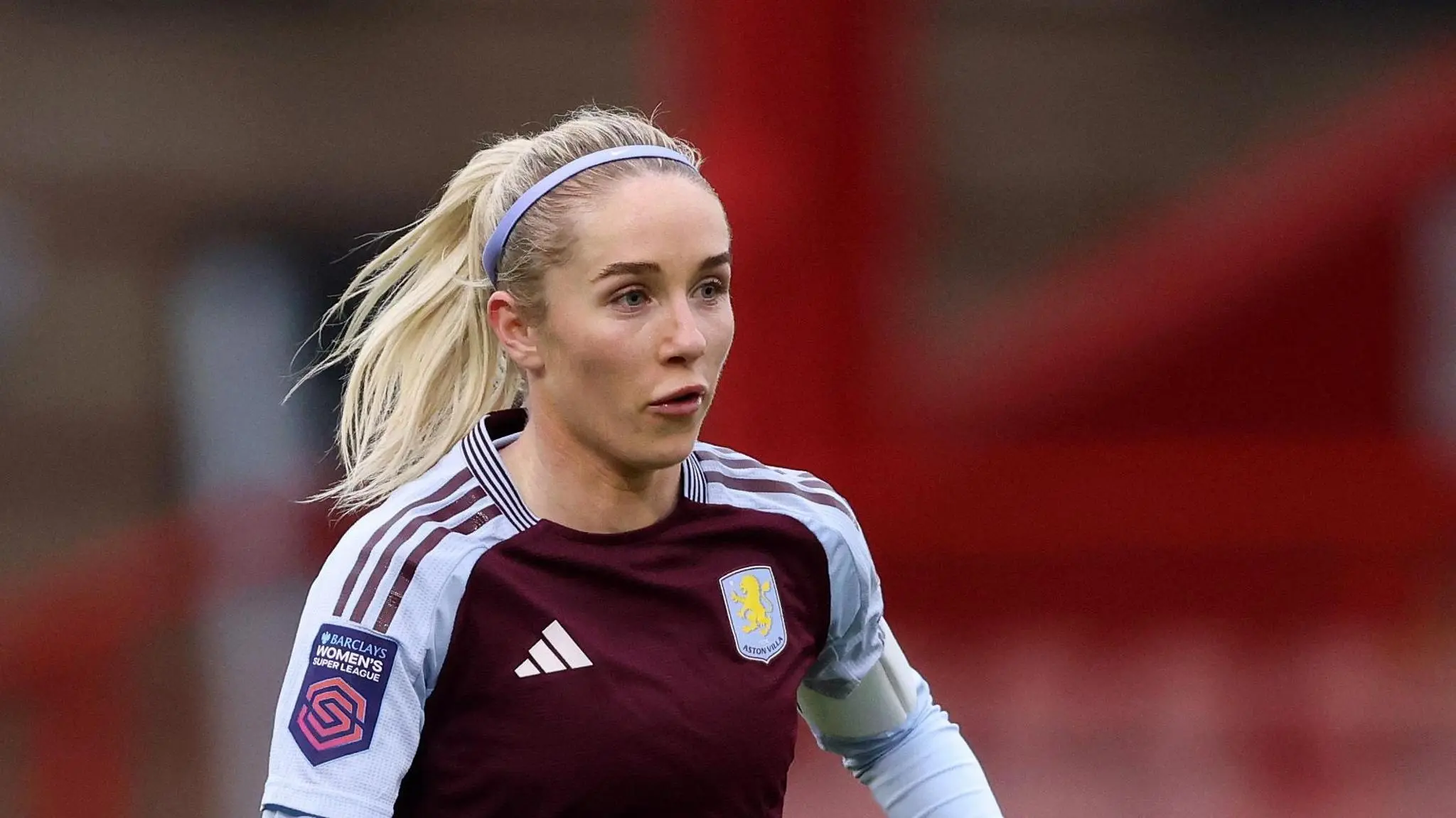 Missy Bo Kearns in Aston Villa kit during a match, showing focused expression.