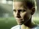 Female footballer showing resilient expression, representing courage and recovery after medical emergency