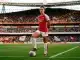 Arsenal Women player in red kit standing confidently on football pitch at Emirates Stadium