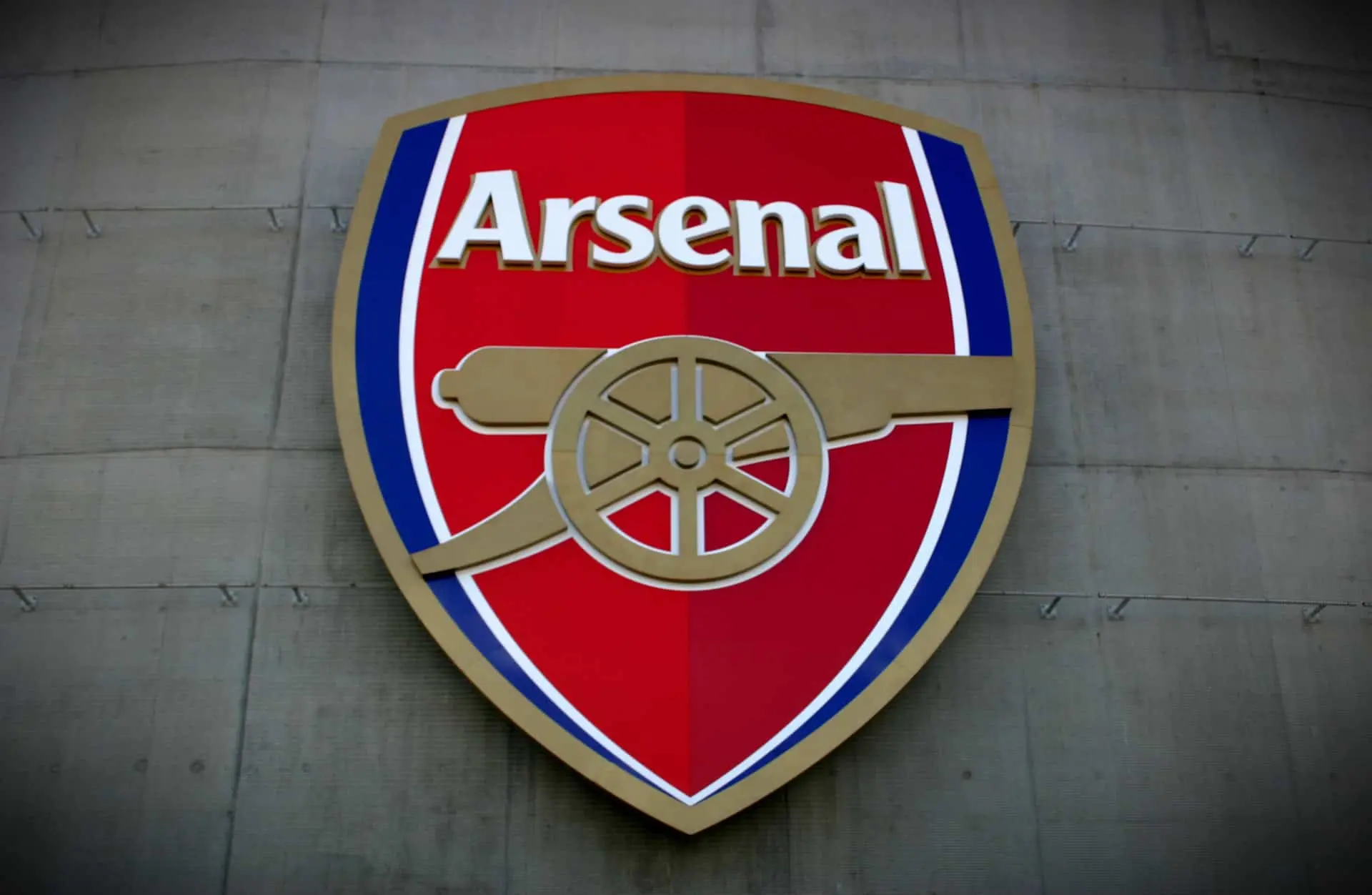 Arsenal FC logo on a wall, representing the women's team at Emirates Stadium.