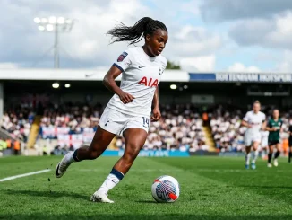 Female midfielder in Tottenham kit controlling football during WSL match