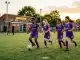 Young girls training on community football pitch at grassroots level with local facilities