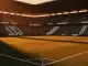 Floodlit stadium at dusk with emerald and white terraces, empty pitch with dramatic shadows and golden-hour lighting