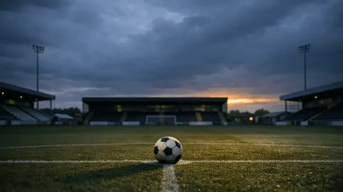 Empty football stadium at dusk with lone ball on pitch representing Durham Women FC uncertain future