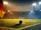 Floodlit stadium corner view with penalty spot under evening lights, black-red-blue-yellow colour palette, dramatic shadows.