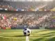 Crowded stadium stands with national flag bunting, floodlit pitch with ball on centre spot, dramatic shadows.