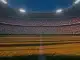 Floodlit stadium at dusk with packed crowd in Japan and Sweden national colours, geometric shadow patterns on grass pitch.