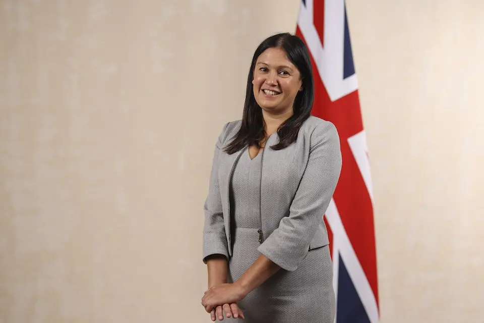 Lisa Nandy smiling in front of a Union Jack flag.