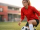 Female footballer in Manchester United kit at training ground ready for defensive play