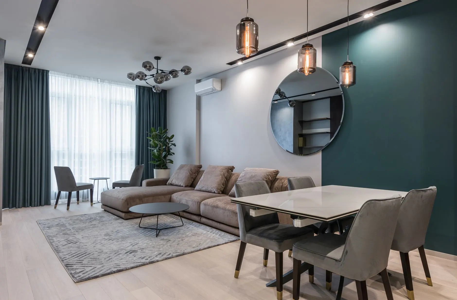 Modern apartment living room featuring a sectional sofa, dining table, and stylish decor.
