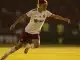 Female footballer in defensive action on pitch showing athletic positioning and tactical awareness