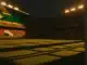 Floodlit stadium pitch at dusk with dramatic shadows, packed stands, and flag-colour lighting design for South Africa vs South Korea.