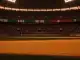 Floodlit stadium at golden hour with packed stands, dramatic shadows, and Swiss red/Algerian green colour palette.