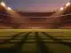 Floodlit stadium at dusk with packed stands and dramatic shadows on empty pitch; sky blue and red atmospheric lighting.