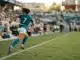 Women's soccer player in Bay FC kit running down the pitch during a match