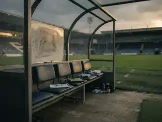Empty manager's dugout at a women's football stadium during golden hour, symbolizing coaching transition
