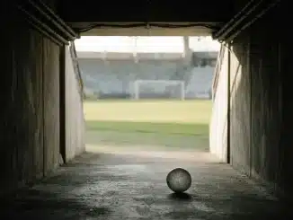 Empty stadium tunnel and football symbolise uncertainty around Poland's Under-20 Women's World Cup.