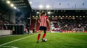 Young women’s footballer in red and white beginning a new season of first-team experience