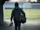 Female football defender walking toward a stadium pitch during a club transfer