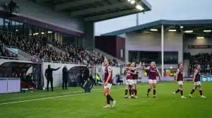 Women’s football match scene showing a tense substitution controversy at a stadium touchline